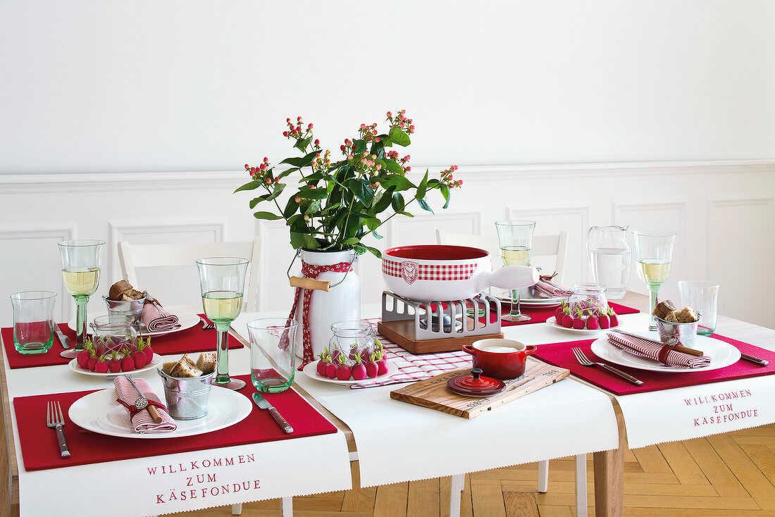 Table decorated with cheese, wine glasses and crockery