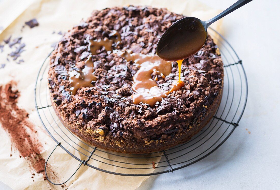 Caramel sauce being drizzled over a chocolate cake