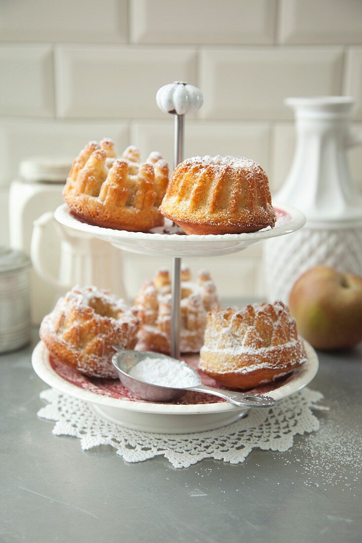 Kleine Apfel-Mandel-Guglhupfe mit Puderzucker auf Etagere