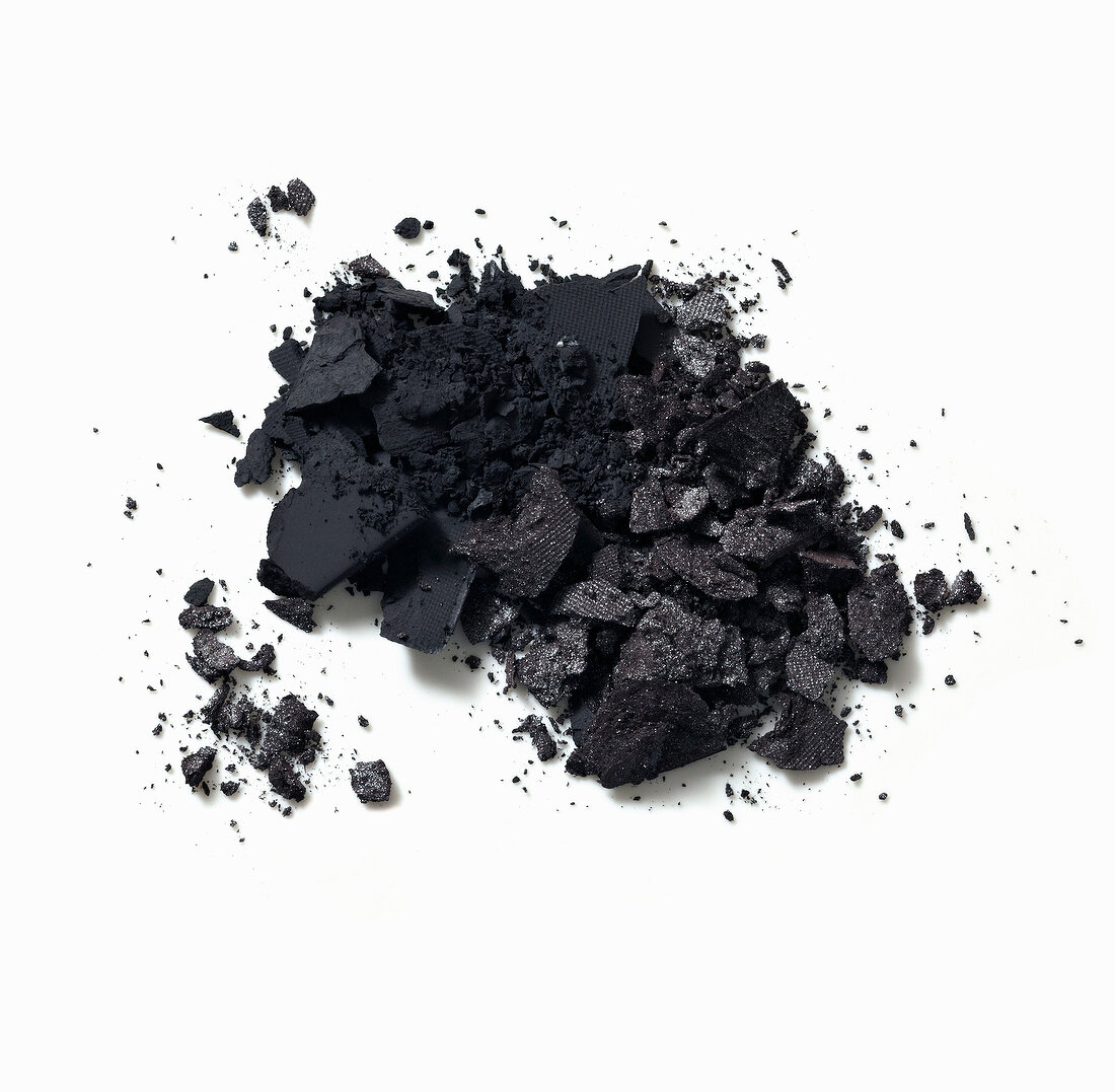 Close-up of loose black eye shadow on white background
