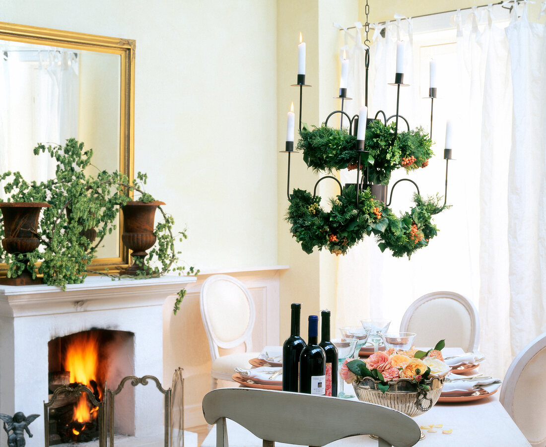 Christmas wreath decorated on chandelier above table with mistletoe in living room