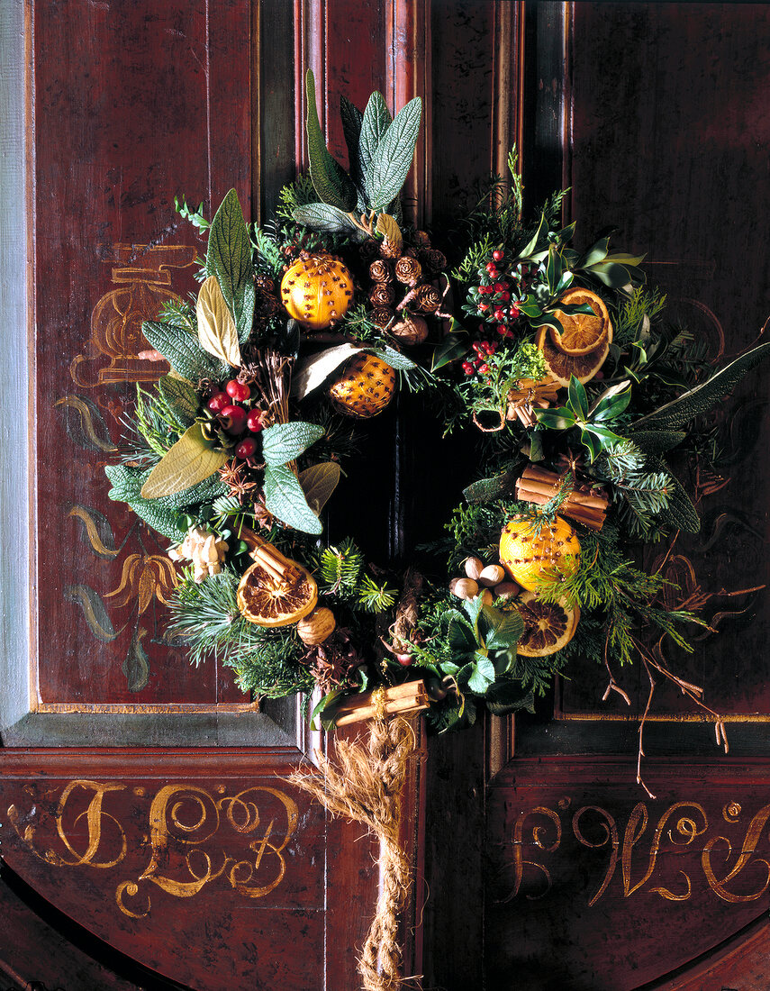 Weihnachtskranz mit Orangen, an verz ierter Tür