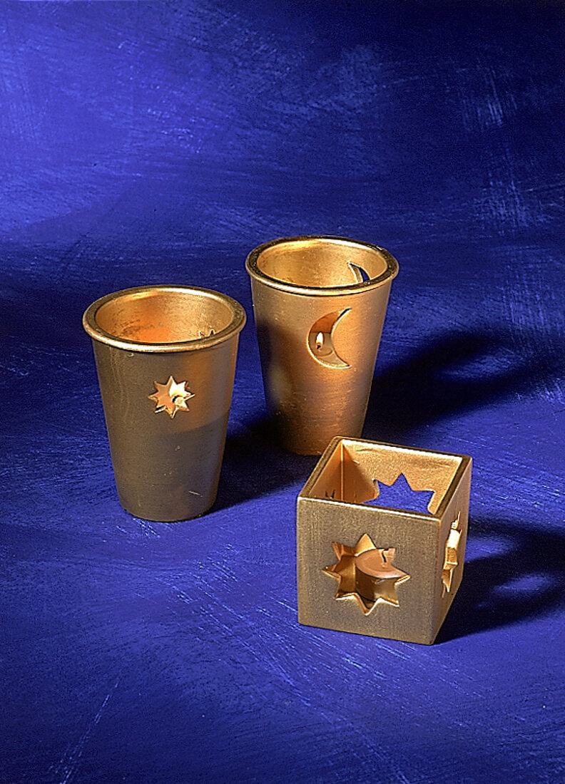 Goldene Kerzenhalter mit Teelichtern blauer Hintergrund