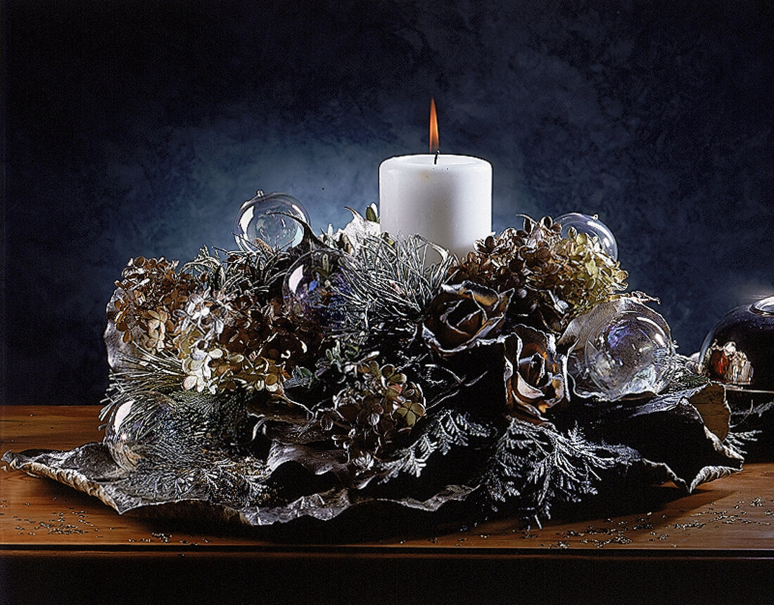 Adventsgesteck mit durchsichtigen Glaskugeln und weißer Kerze