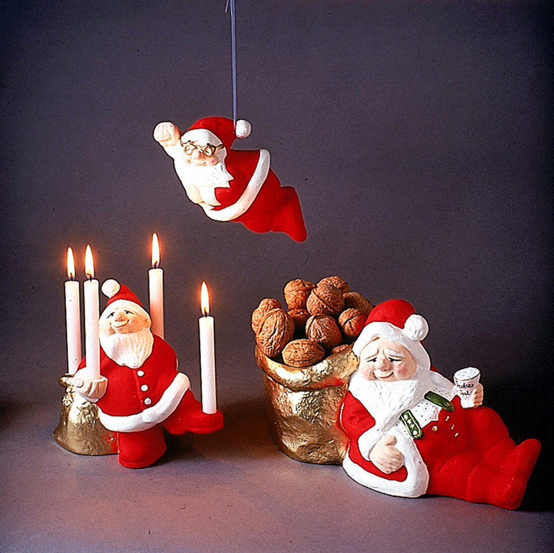 Drei lustige Weihnachtsmänner vor schwarzem Hintergrund