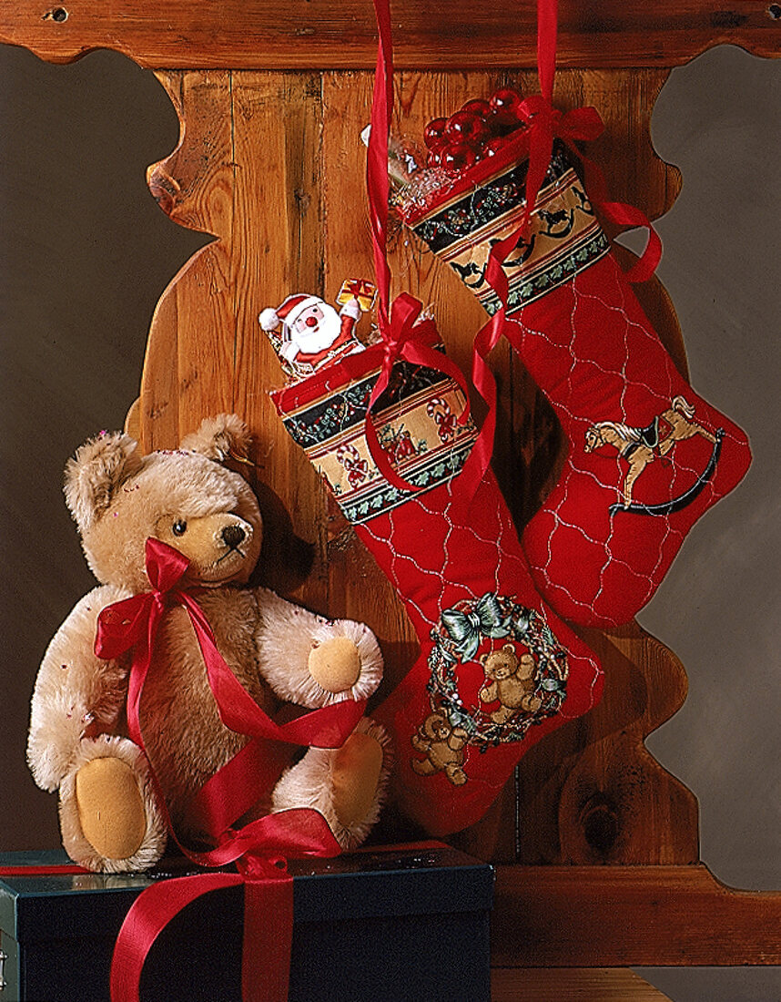 Zwei hängende Nikolausstiefel und ein großer Teddybär