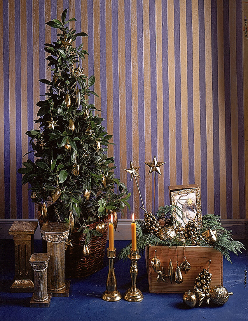 Topfpflanze mit goldfarbenem Weihnachtsschmuck, griechische Säulen