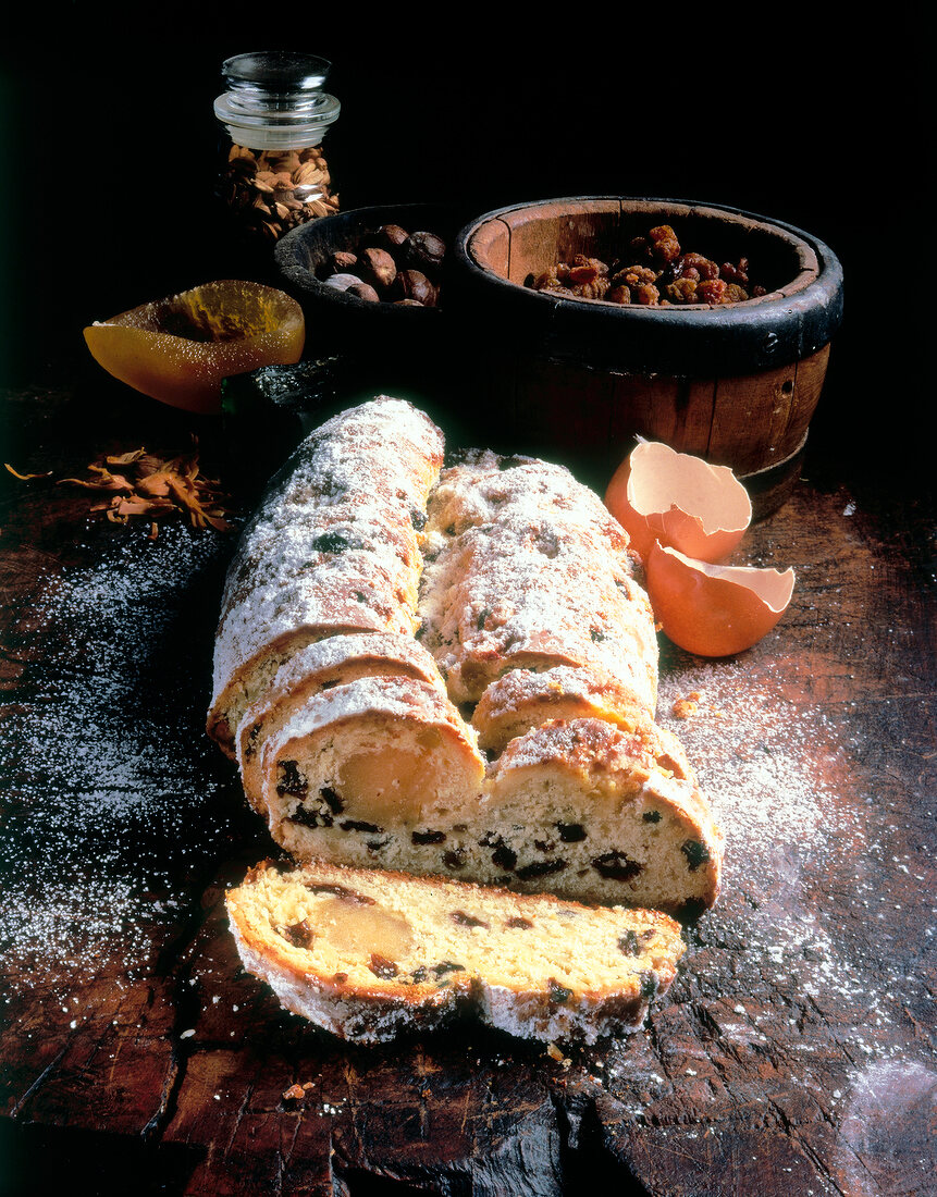 Two half egg shells and slices of marzipan stollen on wooden board