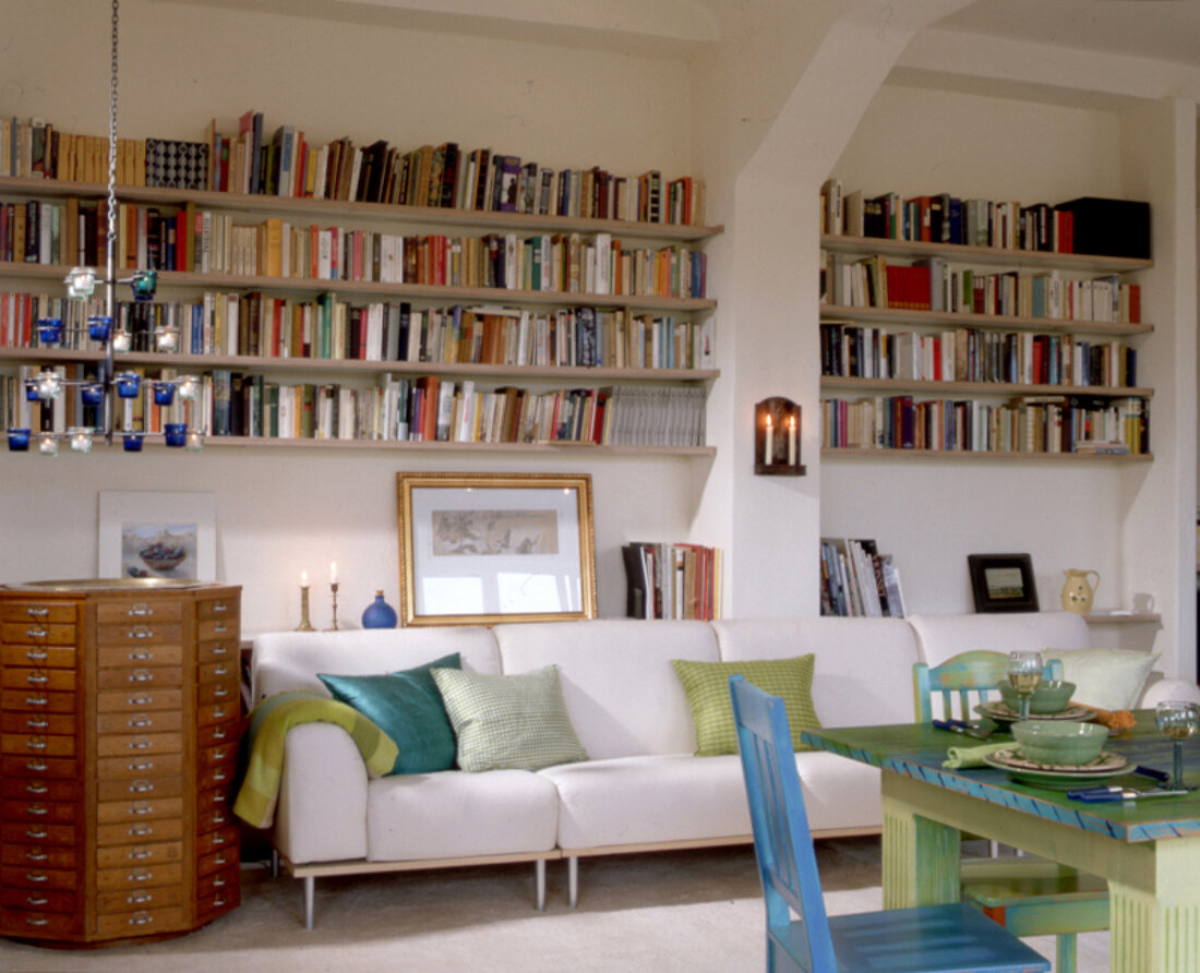 Wohnzimmer mit Bücherregalen, weißes Sofa