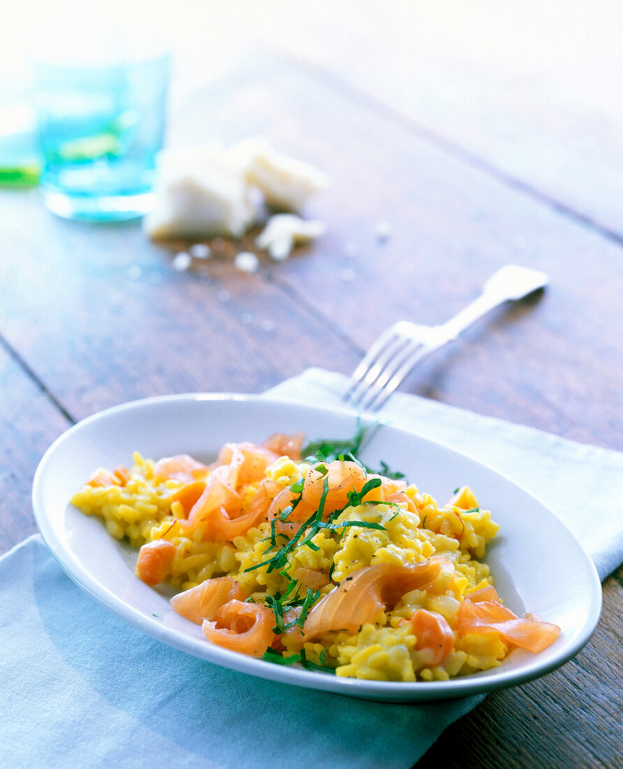 Saffron risotto carrots with smoked salmon in white serving dish