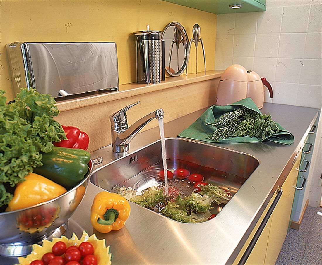 Gemüse wird in der Küchenspüle gewaschen
