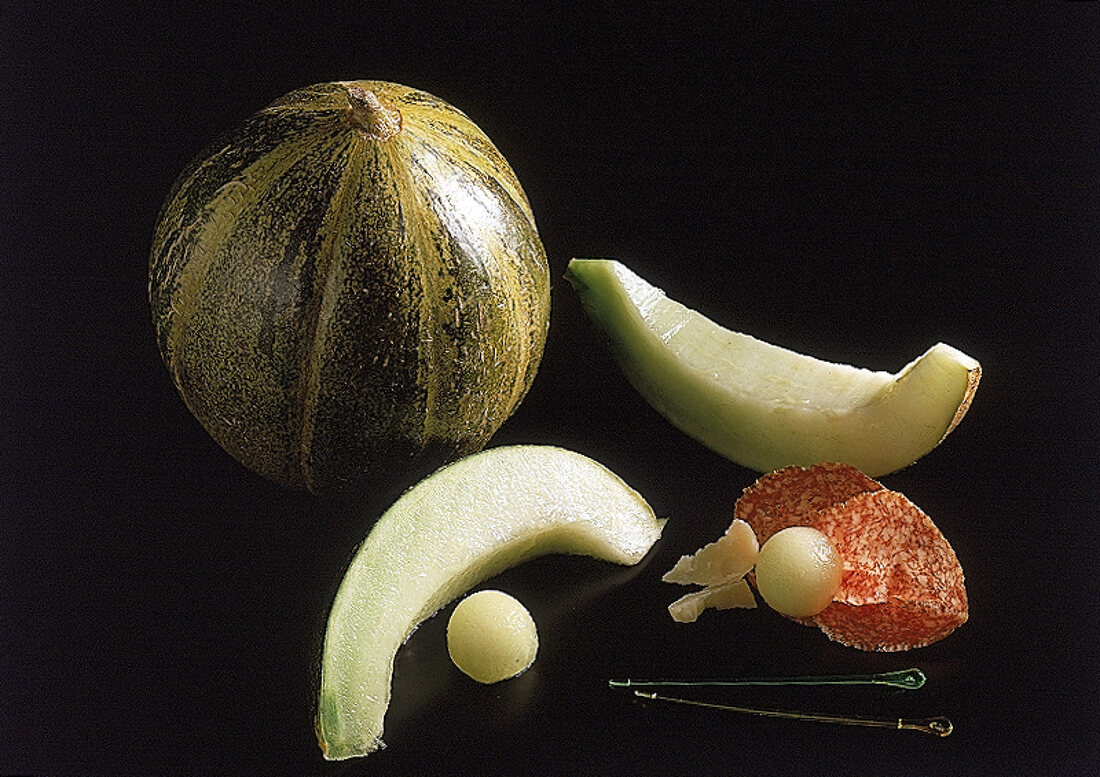 Eine ganze Ogenmelone, daneben zwei Stuecke