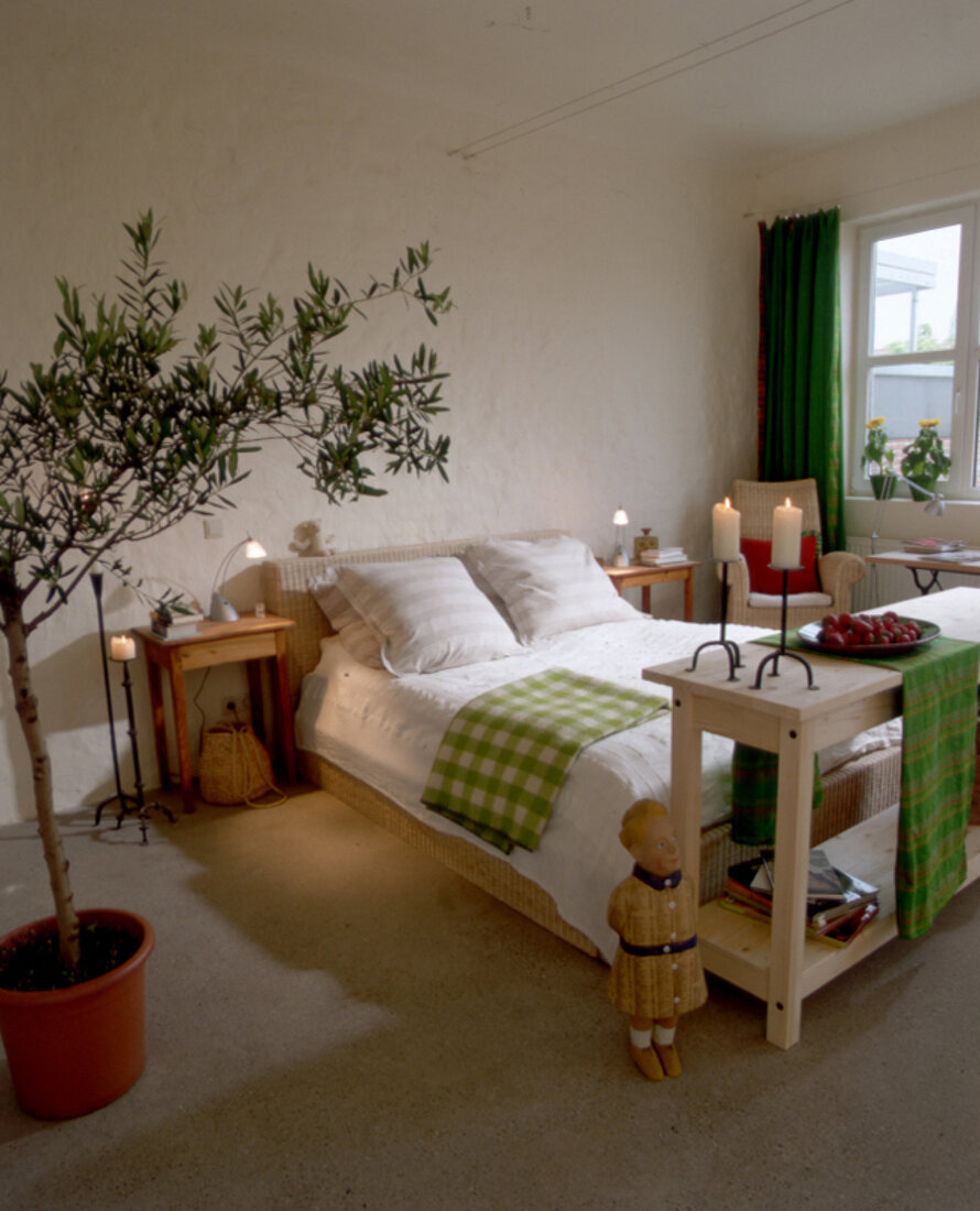 Schlafzimmer mit Rattanbett mit grünkarierter Decke