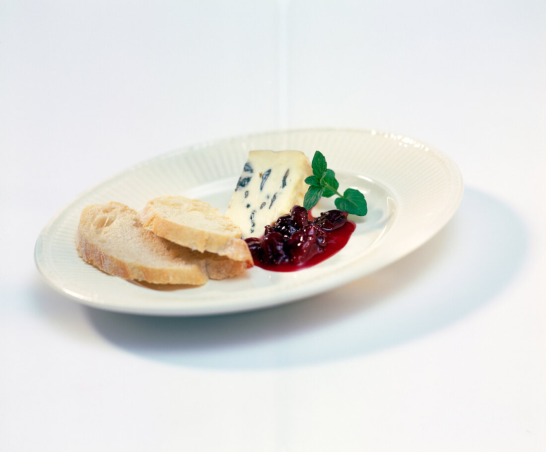 Two slices of white bread with gorgonzola cheese and jam on plate