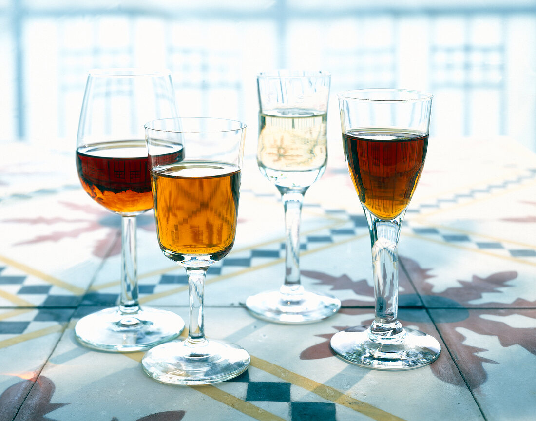 Vier langstielige Gläser mit ver- schiedenen Sorten Sherry
