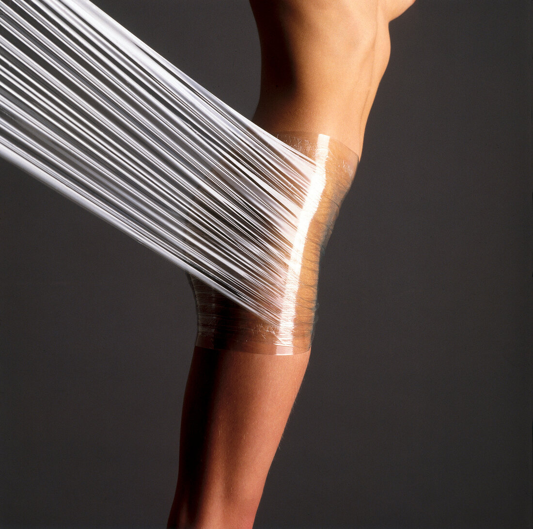 Nackter Frauenkörper wird mit Folie umwickelt, Aroma Therapie