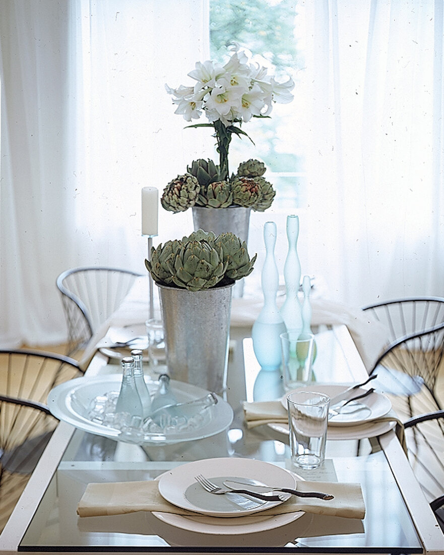 Hell gedeckter Tisch mit Artischoken und Lilien dekoriert