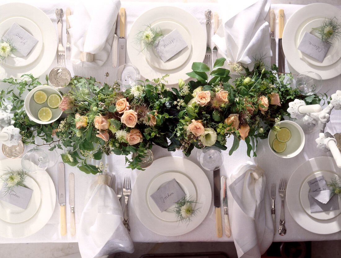 Weiß gedeckter Tisch mit üppigem Blumenarrangement