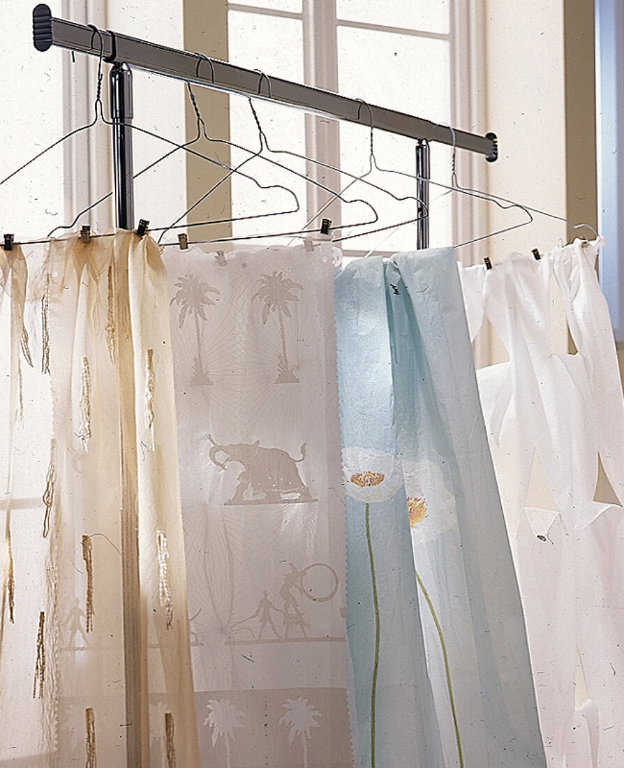 Transparente Vorhangstoffe aufgehängt auf Kleiderbügeln aus Draht