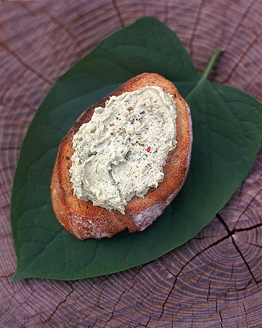 Eine Scheibe Brot liegt auf einem Blatt,belegt mit Spargelcreme,Nr.4