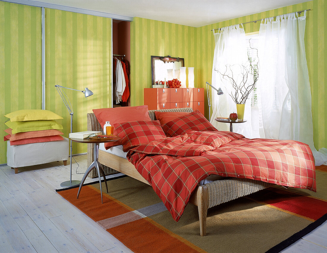 Schlafzimmer: Grüngestreifte Wände, Korbbett, rote Kommode