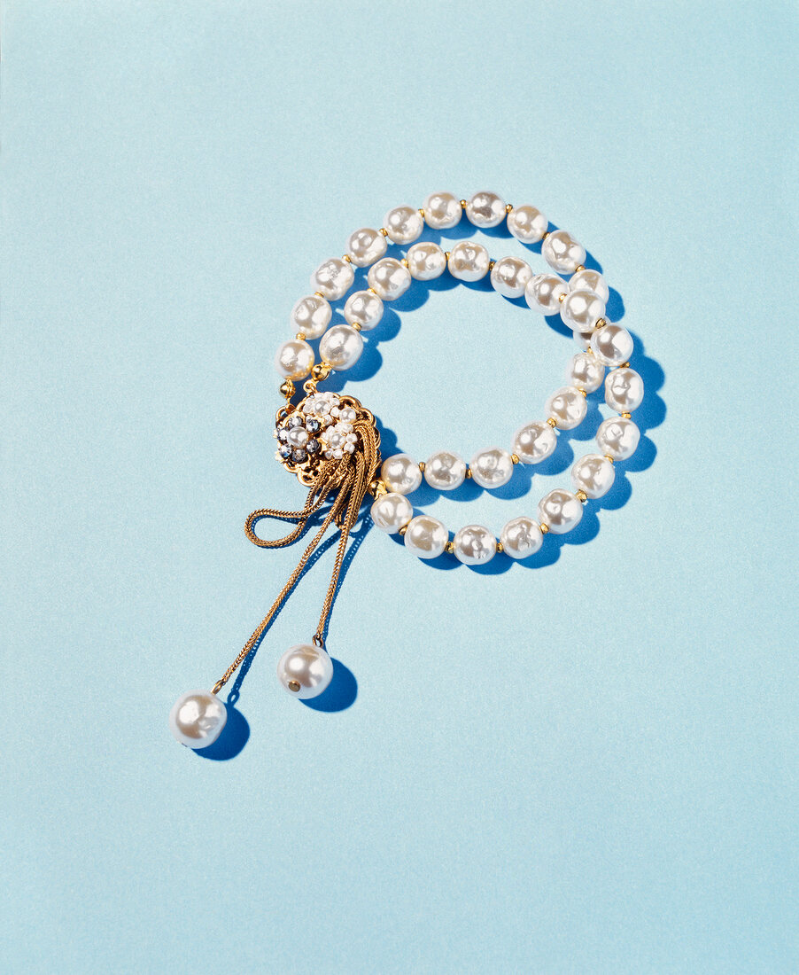 Bracelet of baroque pearls on blue background