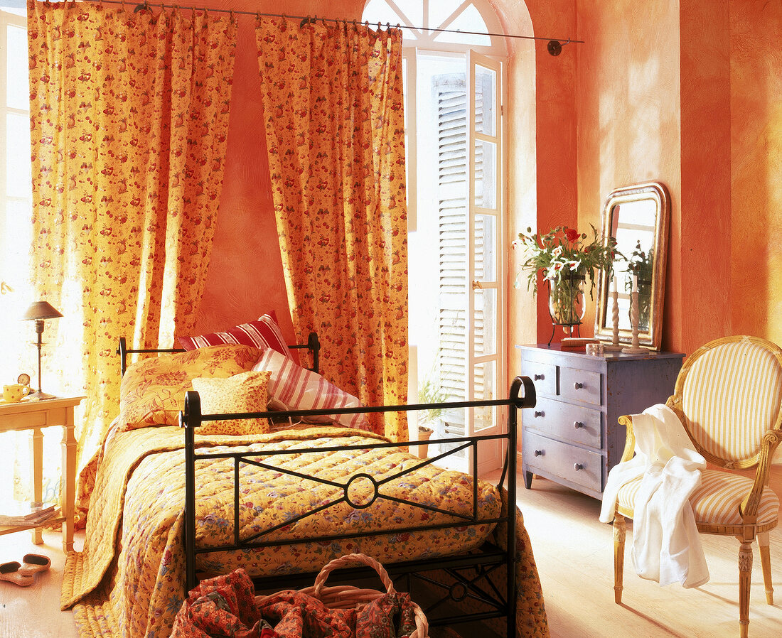 Schlafzimmer im Stil der Provence durch Tagesdecke und Vorhänge