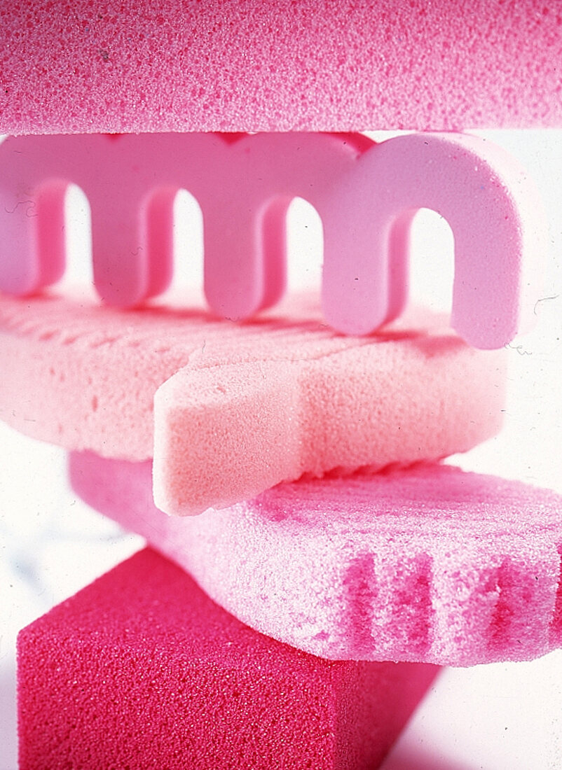 Pinkfarbener Zehenspreitzer und pink u. rosafarbene Bimssteine, gestapelt