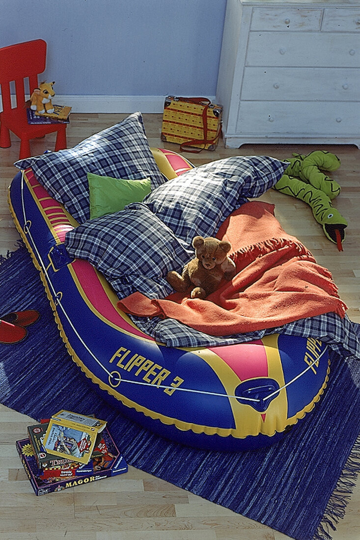 Schlauchboot als Kindergästebett mit Kissen und Decken, Teddy