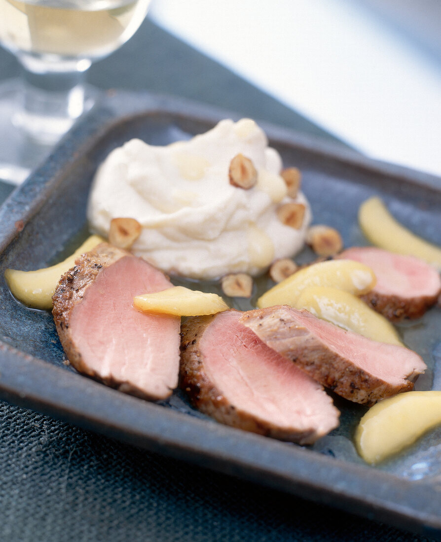 Pork fillets with celery cheese puree and apples on plate
