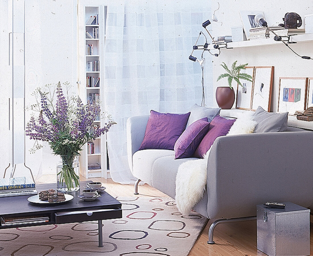 Wohnraum: helles Sofa, darüber Regal als Ablagefläche