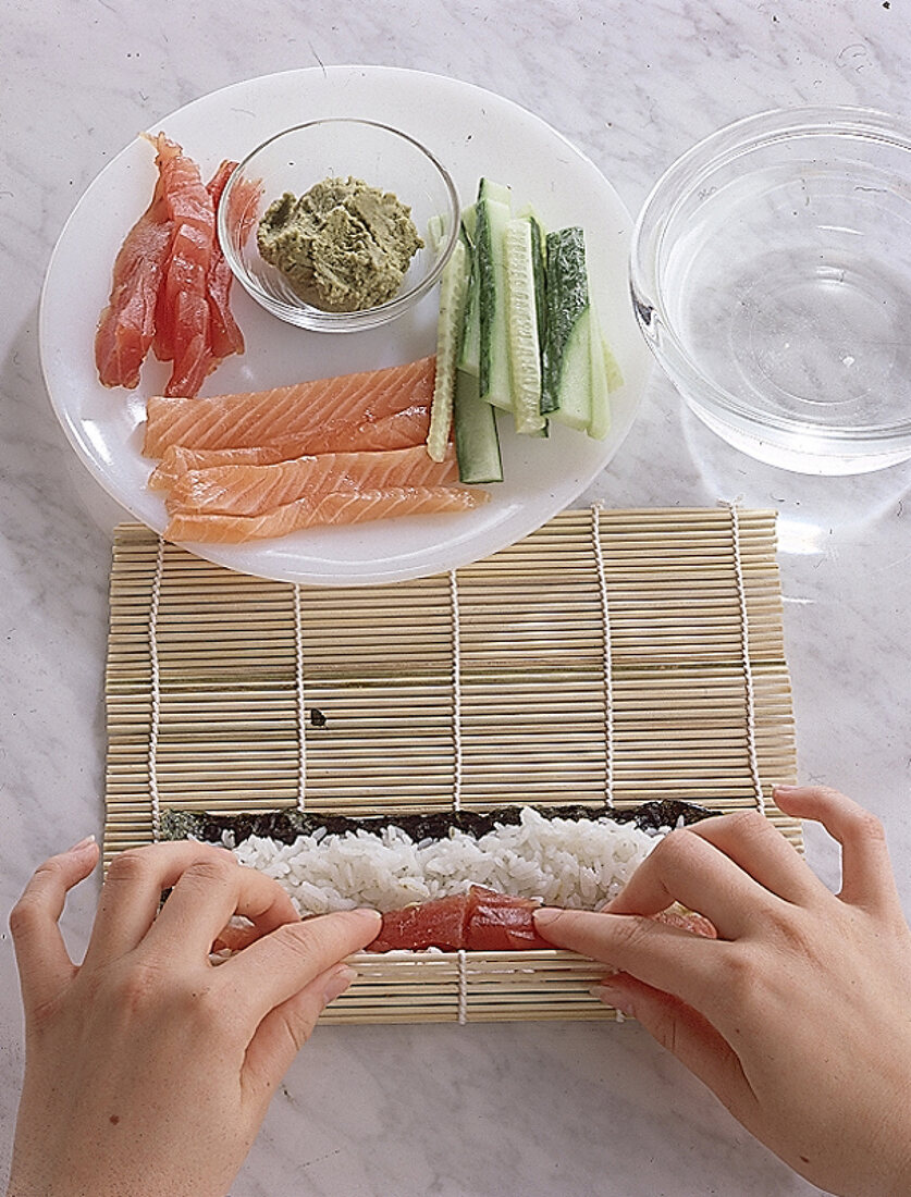Maki - Sushi mit der Bambusmatte zu einer Rolle wickeln. Step.:5