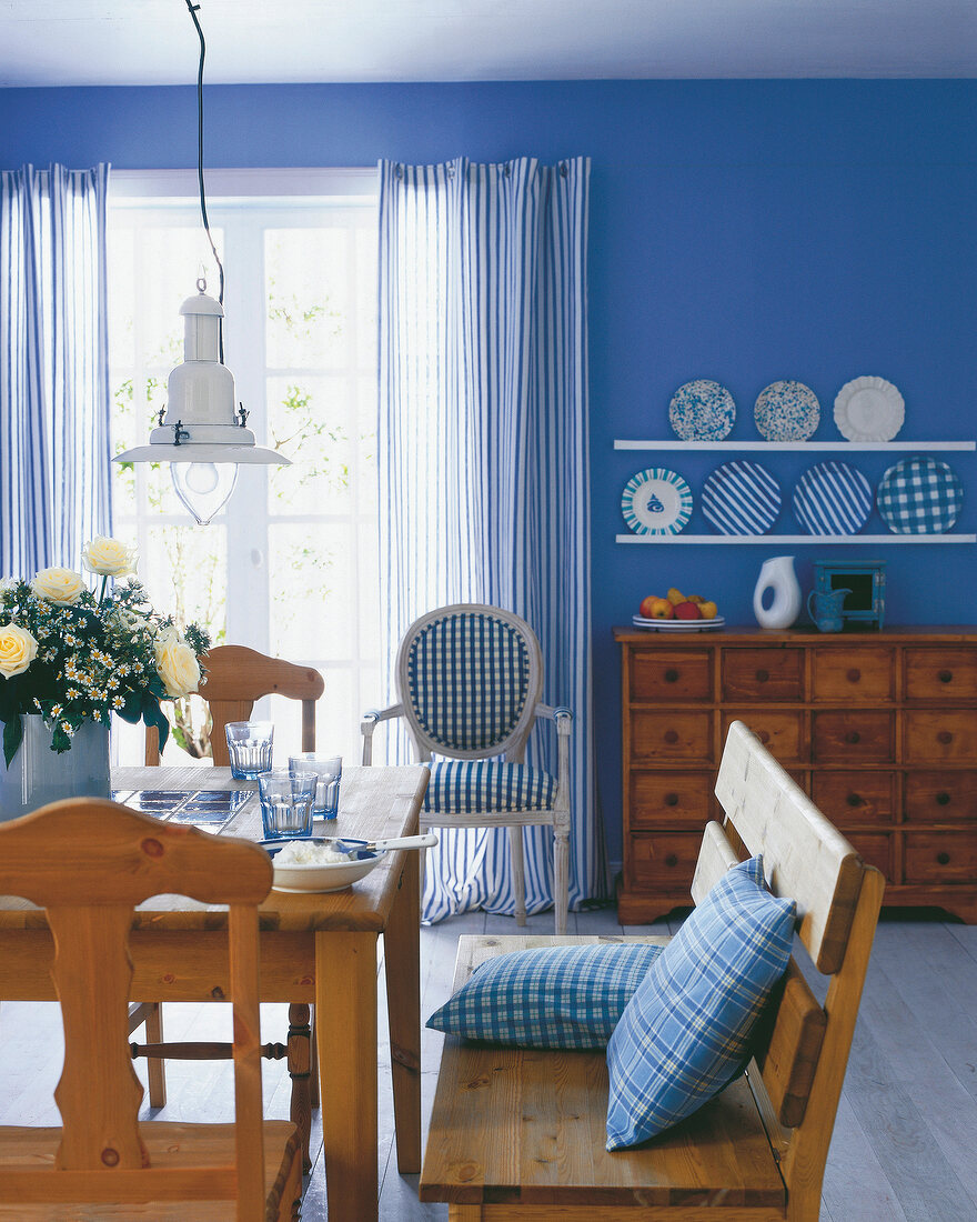 Blue and white painted dining area with rustic pine furniture