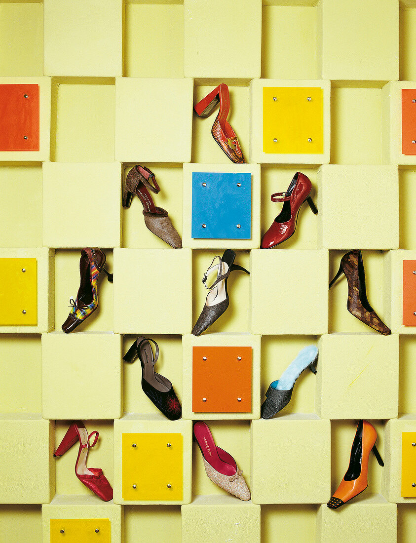 Various types of shoes on yellow shelf