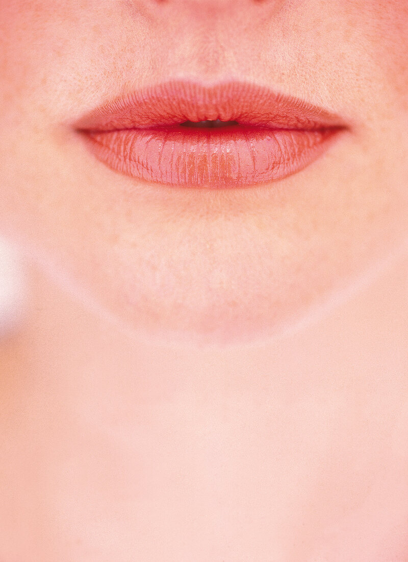 Extreme close-up of woman wearing red lipstick