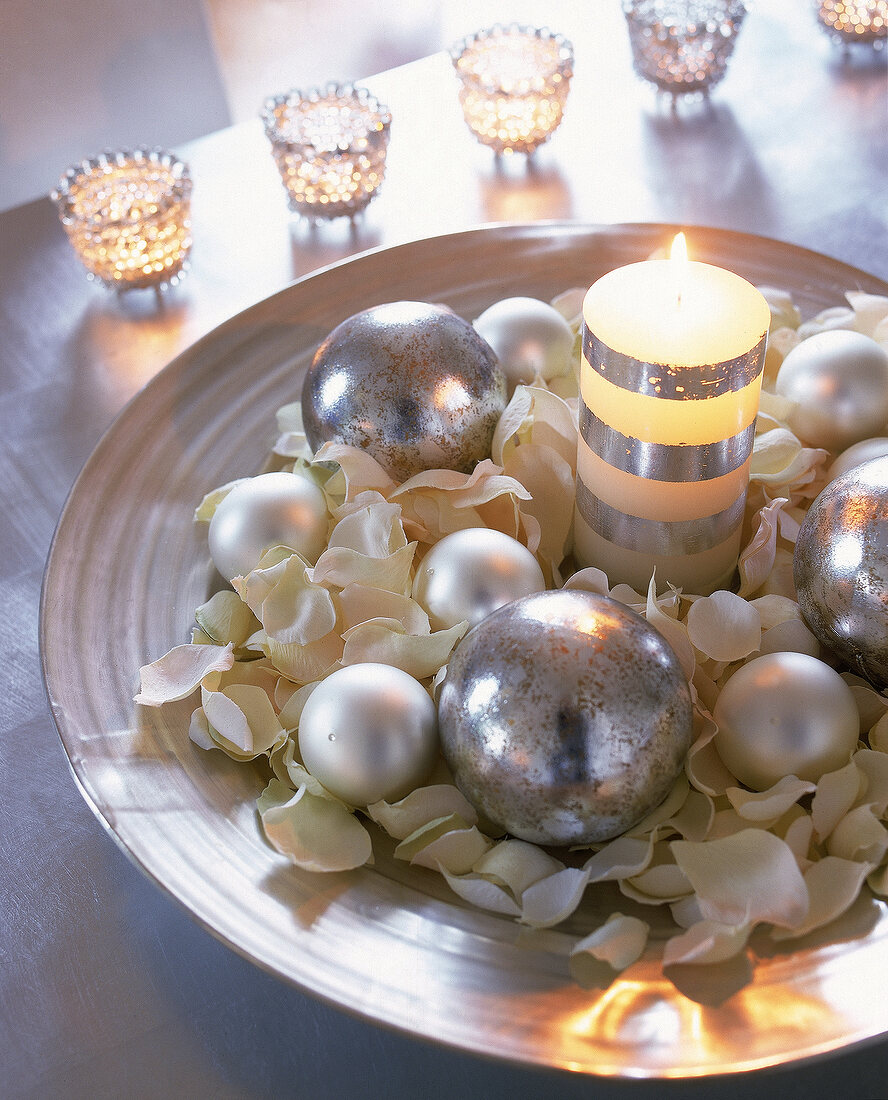 Silberschale gefüllt mit Blütenbett, Silberkugeln u. gestreifter Kerze