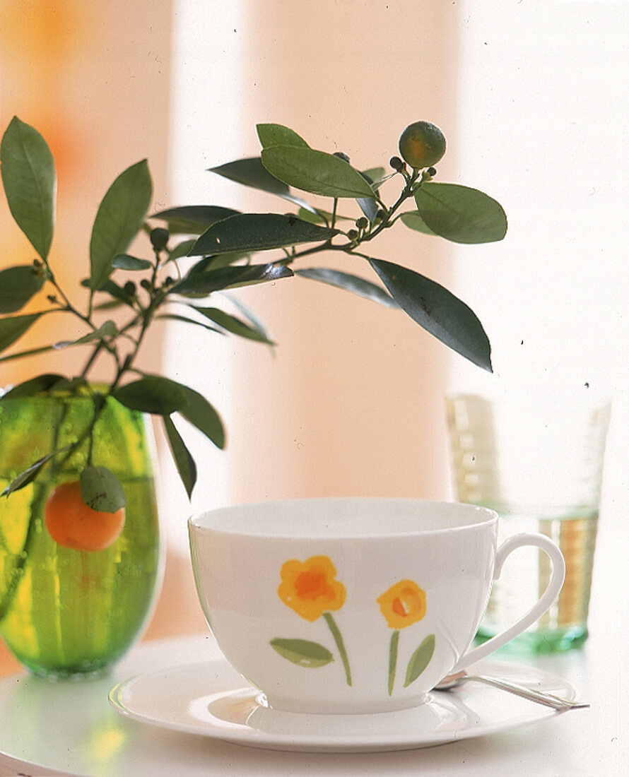 Kaffeetasse in sommerlichem Design mit kleinen Blumen, grüne Vase