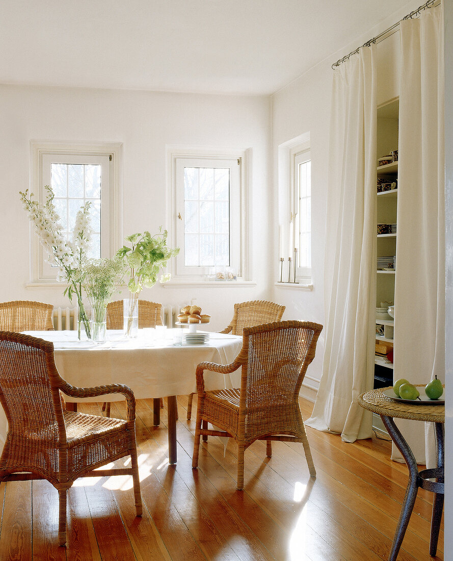 Eßzimmer, schlicht, mit Holztisch, Rattansesseln und Regal für Geschirr
