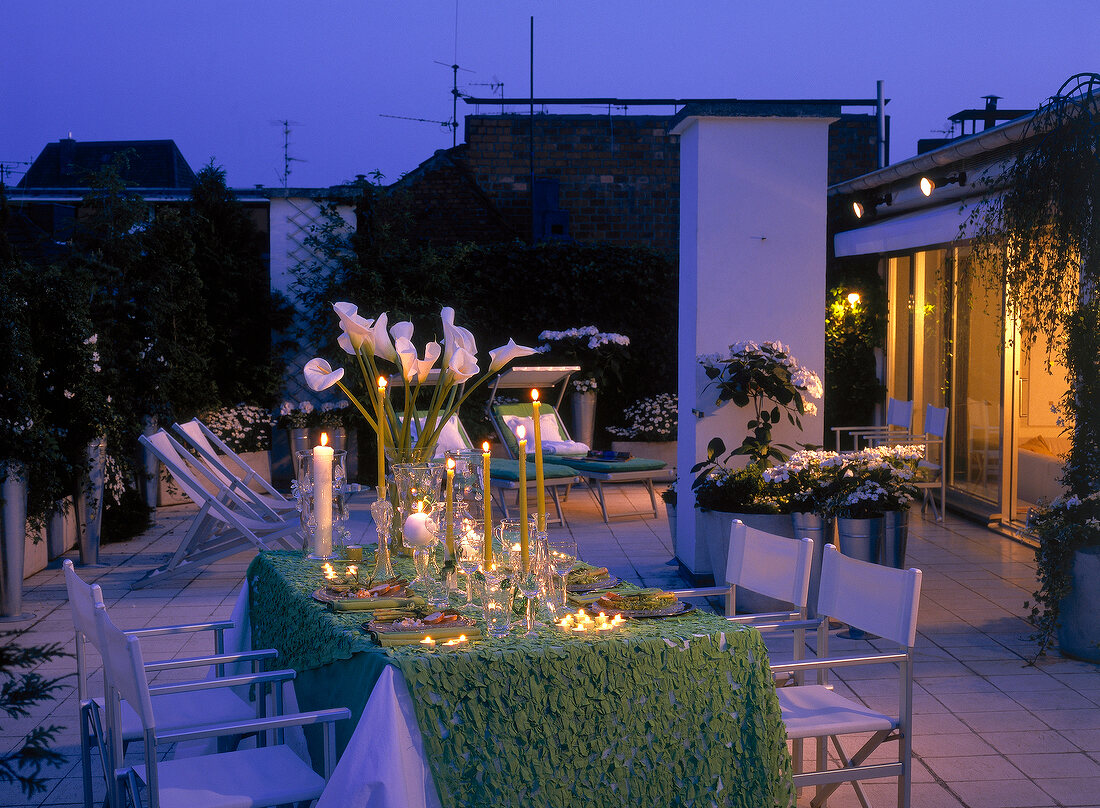 Festlich gedeckter Tisch auf einer Dachterrasse, Abendstimmung