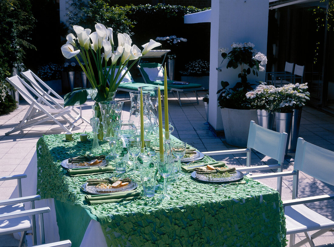 Decorated table with candles, flowers and plates on rooftop terrace