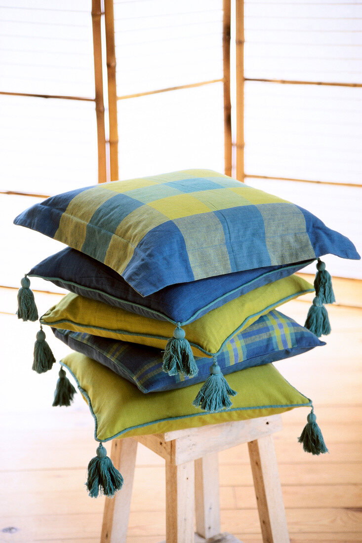Cushions in blue and yellow checks stacked on stool
