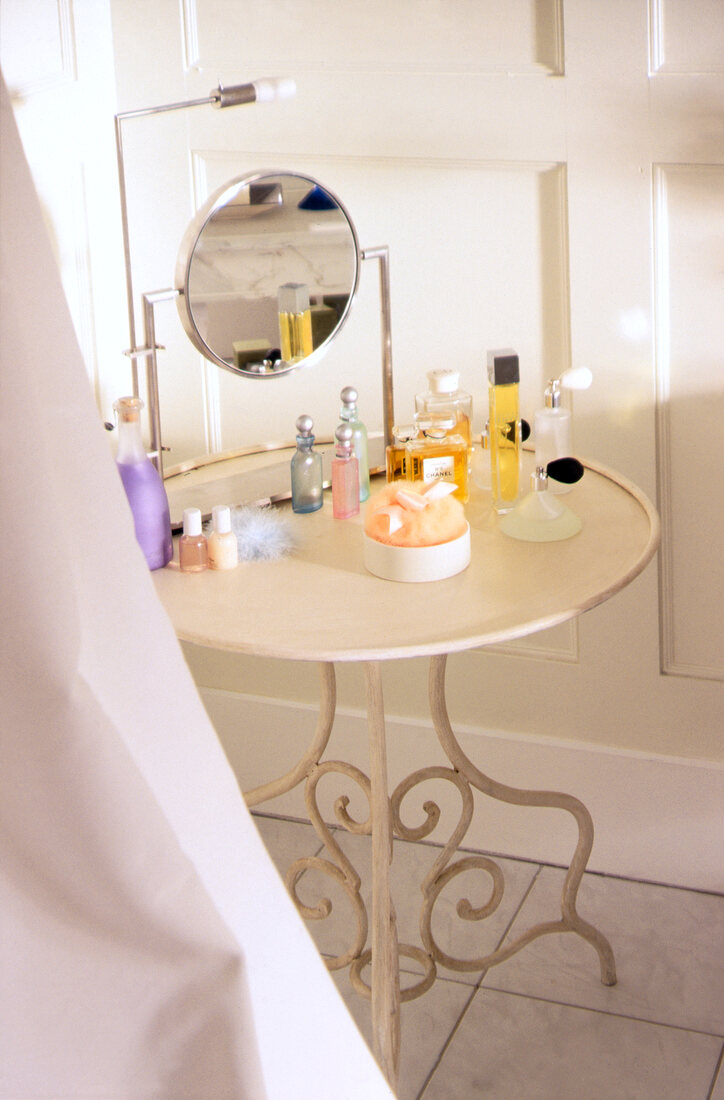 Small table with perfume bottles and mirror