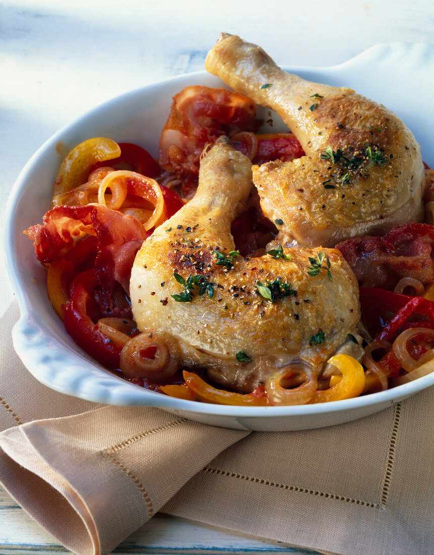 Close-up of chicken legs on peppers in bowl