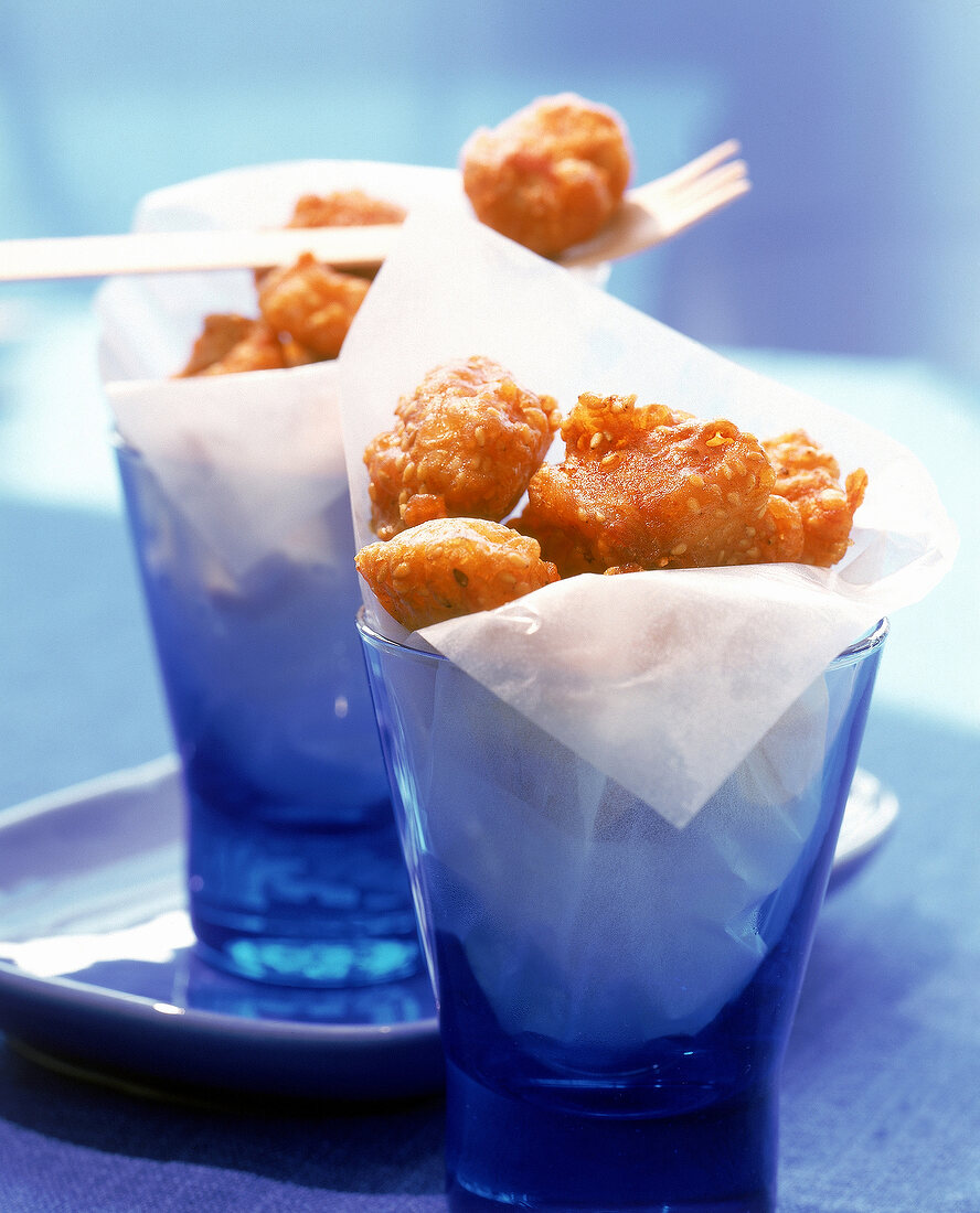 Chicken-Nuggets mit Sesamkruste in blauen Gläsern