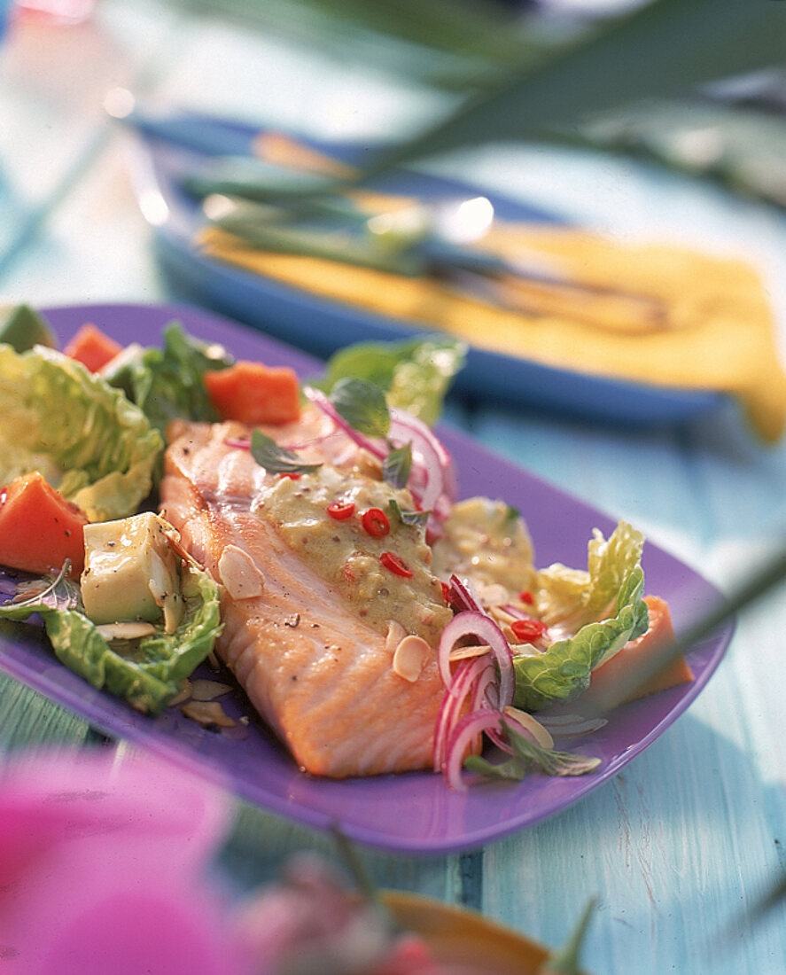 Lachsfilet in Senf-Ingwer-Sauce auf tropischem Salat, Avocado und Papaya