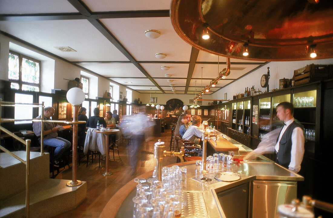 "Pilsener Urquell" Restaurant, lange Theke und Tische mit Gästen