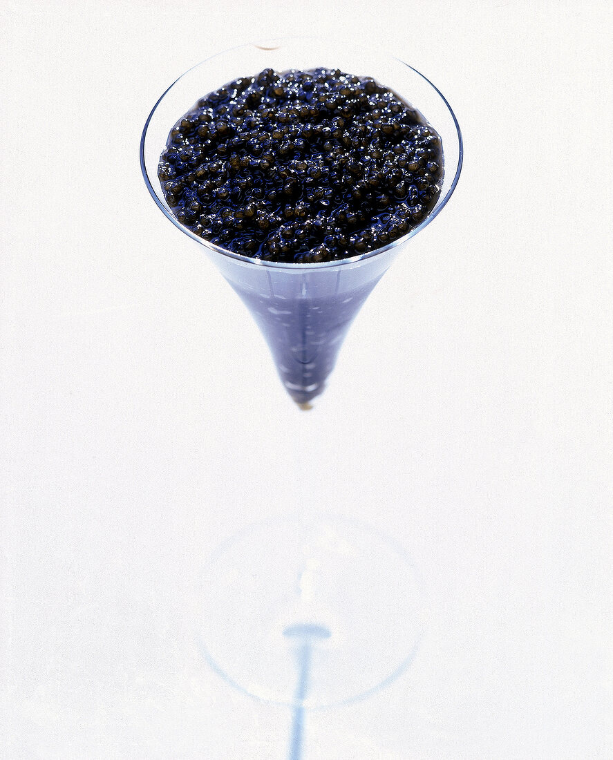 Eine Sektflöte, randvoll mit KaviarPerlen gefüllt