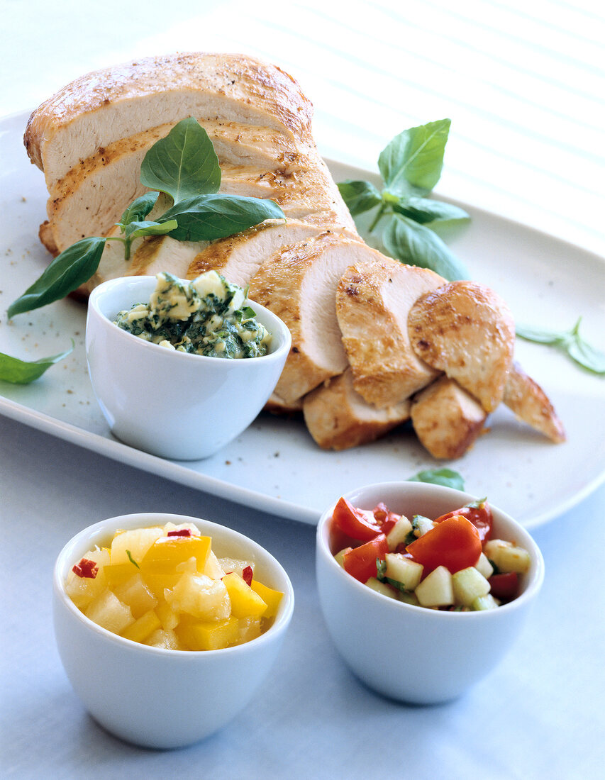 Roasted turkey with three different sauces in small white bowls