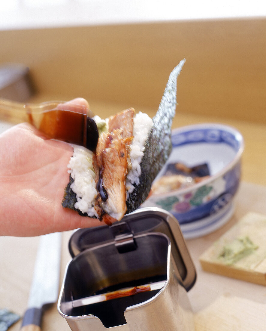 Sushizubereitung: Shakekawa-Temaki, Aalsoße wird in die Tüte geträufelt