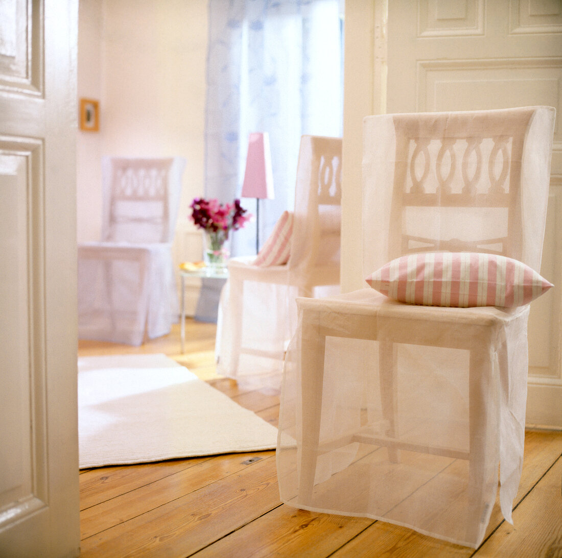 Wooden chair with transparent slipcover and cushion on wooden floor